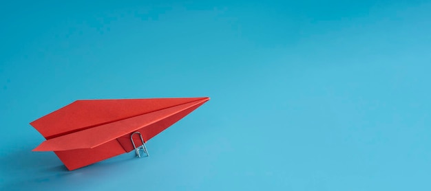 Red paper plane on blue background top view space for text leadership concept