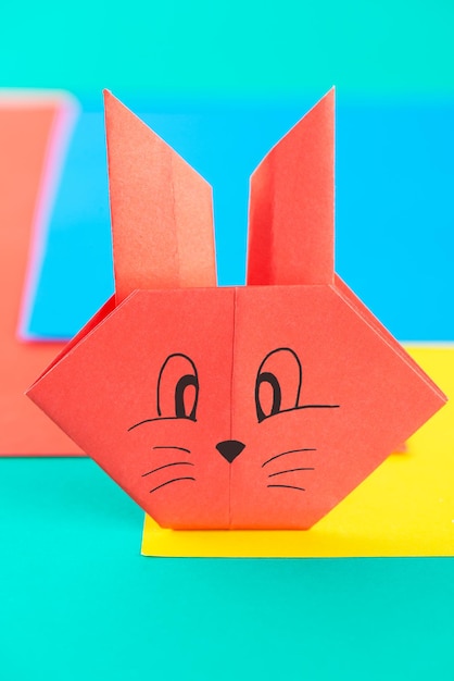 Red paper rabbit on a background of colored paper