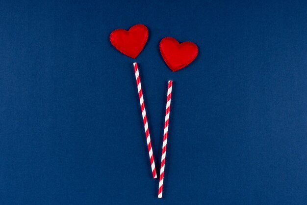 Красная бумажная солома с сердцем на классическом синем цветном фоне 2020 года. день святого валентина 14 февраля концепция. плоская планировка, копия пространства, вид сверху.