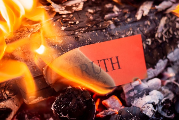 Photo red paper with inscription truth burning in fire