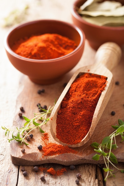 Red paprika powder spice in wooden scoop