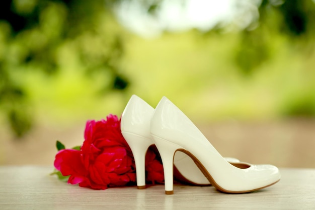 Red peonies with white shoes