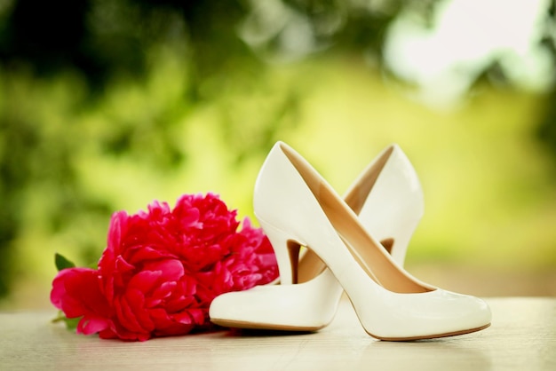 Red peonies with white shoes