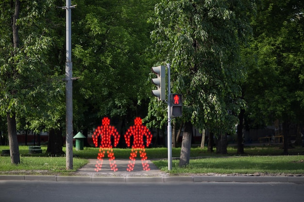 Red people stay near pedestrian crossing and red traffic light