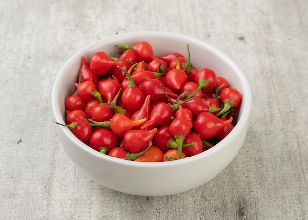 Red pepper pout on a bowl over wooden table.