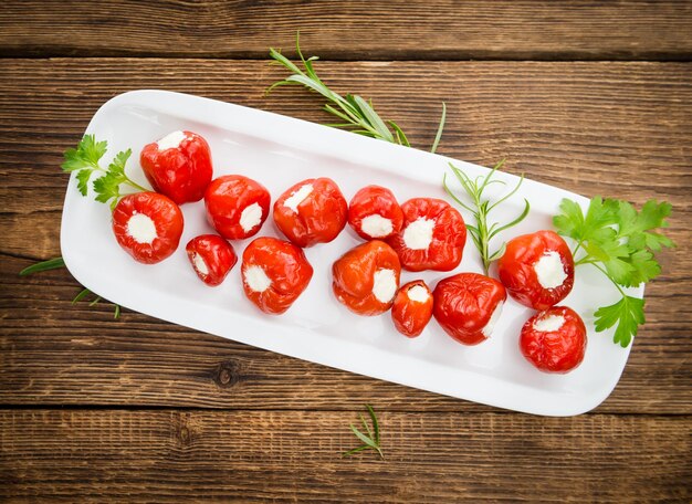 Red Pepper stuffed with cheese on wooden background selective focus