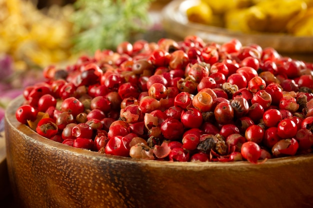 Red peppercorn seeds in wooden plate