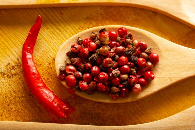 Red peppercorns in wooden spoon