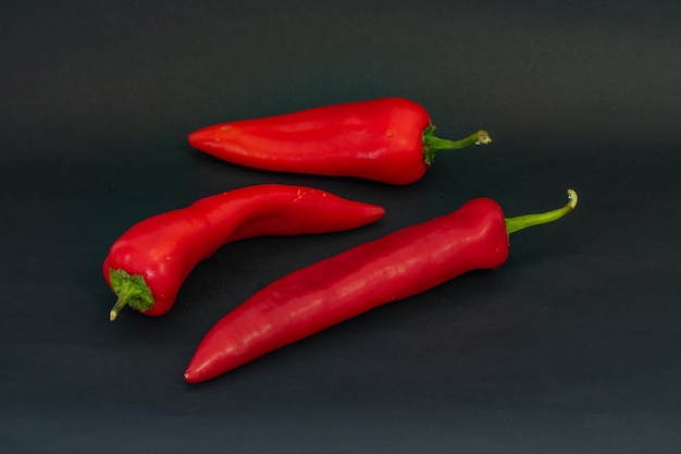 Red peppers on a black background three red peppers on a black background