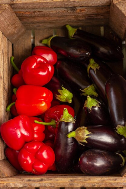 Red peppers and eggplants in wooden box healthy organic food vitamins