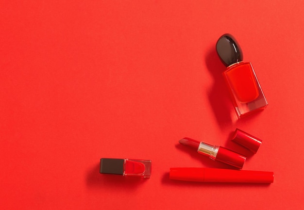 red perfume bottle and cosmetics on red background