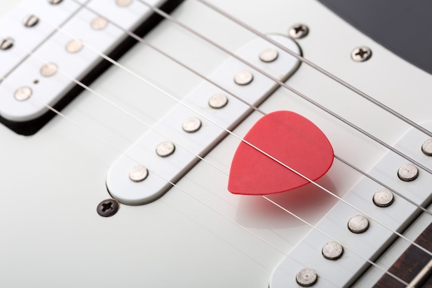 Red pick in electric guitar strings