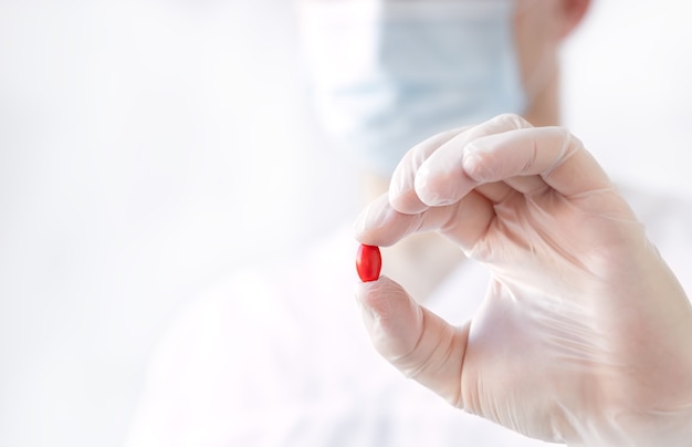 Red pill in doctor's hand