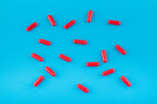 Photo red pills capsules on a blue background