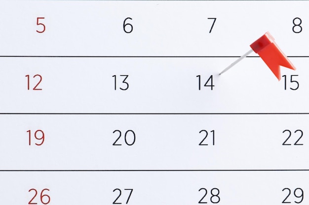 Red pin flag on a calendar. Important date. Place for text. Planning concept.