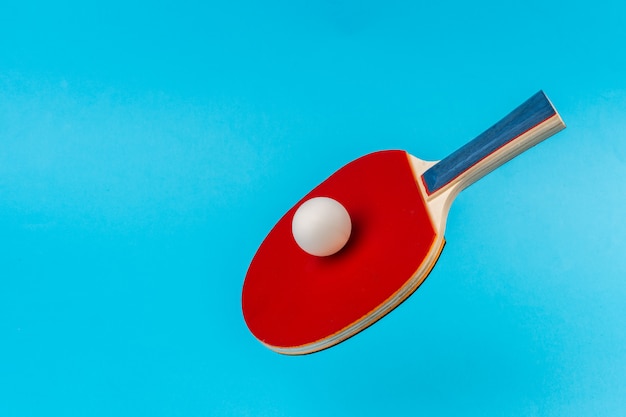 Red ping pong racket on a blue surface