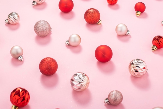 Red and pink decorative balls on a pink background. Top view, flat lay.