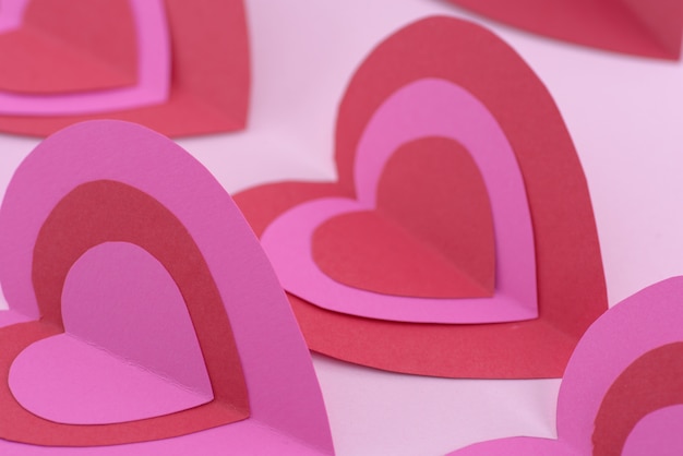 Photo red and pink paper hearts, valentine day background.