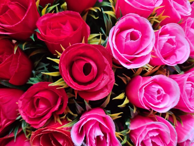 Photo red and pink roses background artificial flowers and floral