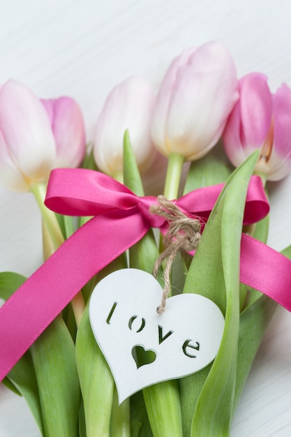 Red pink tulips with red ribbon