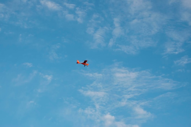 red plane flying on a blue sky