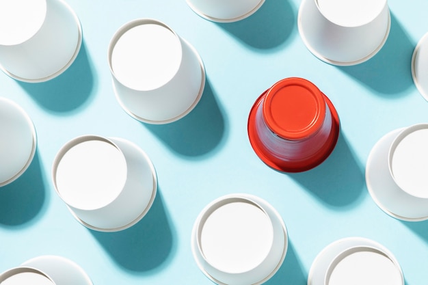 Photo red plastic cup surrounded by paper cups