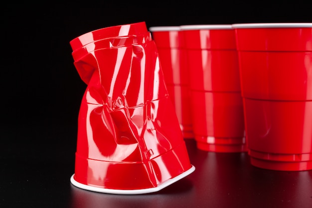 Red plastic cups and ball for game of beer pong