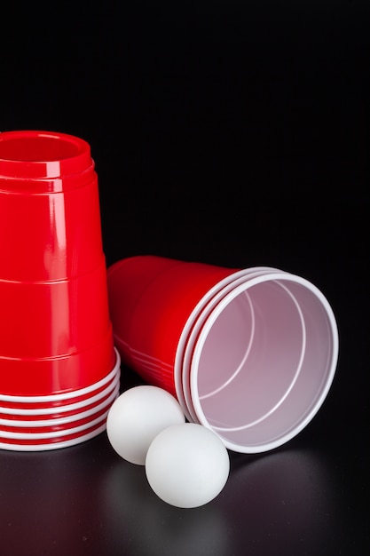 Red plastic cups and ball for game of beer pong