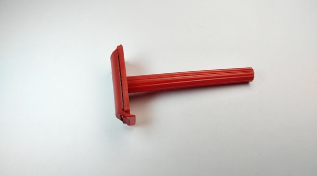 Photo red plastic shaving razor on a white background closeup of photo