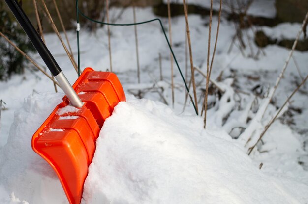 Red plastic shovel with black handle