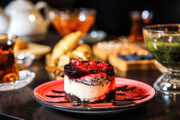 Photo red plate with cake and cup of tea