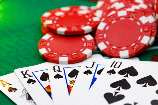 Red playing chips and cards on poker table