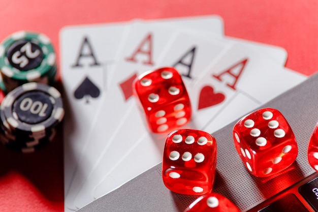 Red playing dice gambling chips and cards with aces closeup