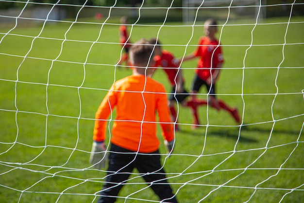 Red playing soccer ball on grass