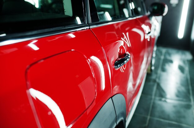 Red polished car in professional detailing garage