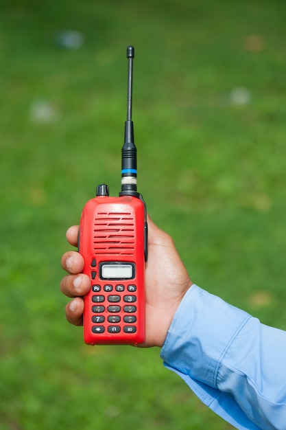 Red portable radio transceiver in hand