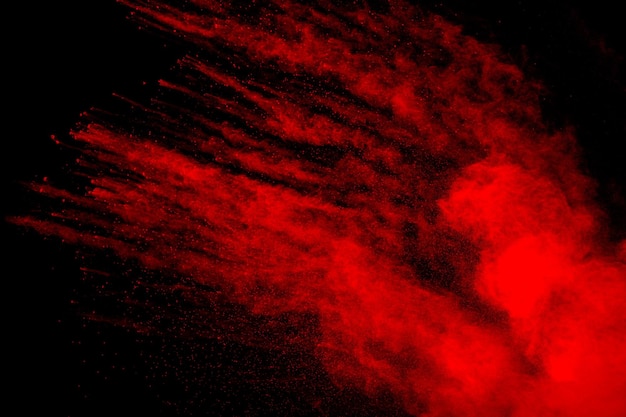 Nube di esplosione di polvere rossa su sfondo nero congelare il movimento di schizzi di particelle di polvere di colore rosso