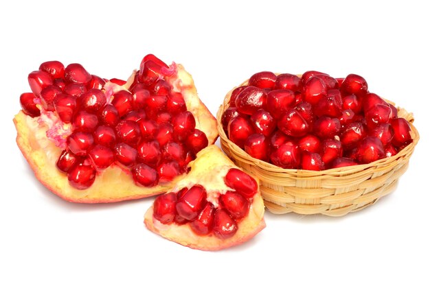 Red Pulp of slices pomegranate fruit on bamboo basket over white background