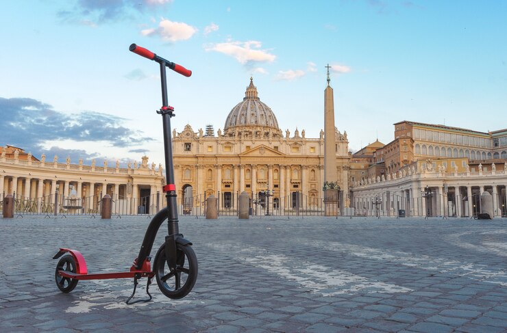 Фотография красные самокаты нажима на фоне ватикана в roma, италии.