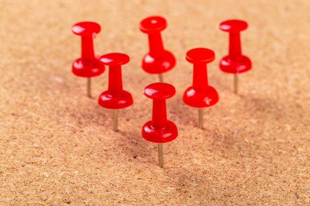 red pushpin pinned to bulletin board