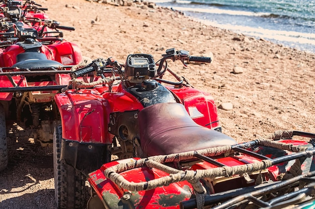 写真 エジプトの赤海の岸に並んで立っている赤い四輪車