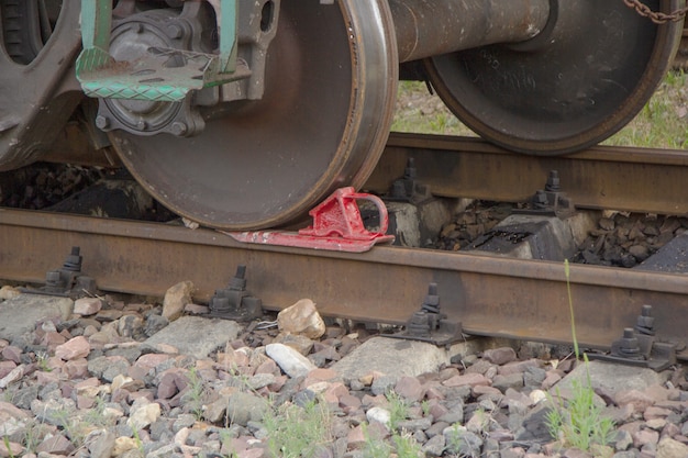 Red rail shoe under the wheel of the carriage on the rails.