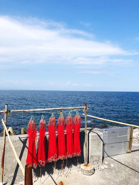 Photo red railing by sea against sky