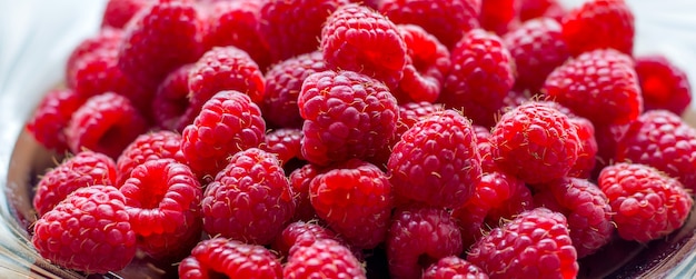 Red raspberries on a plate close-up, berries for consumption