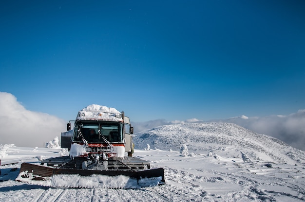 Red ratrak snowcat in winter mountains