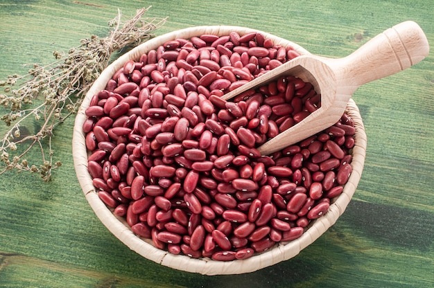 Photo red raw beans on a green table