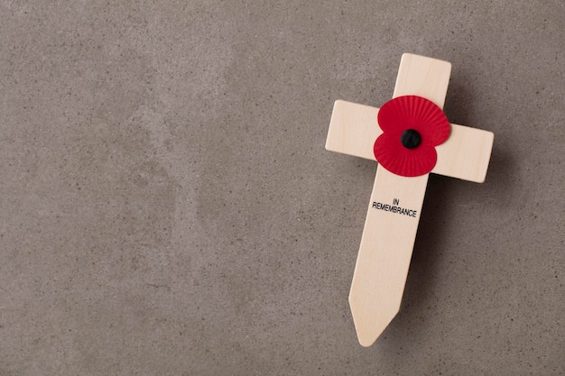 A red remembrance poppy on a wooden cross military remembrance day concept