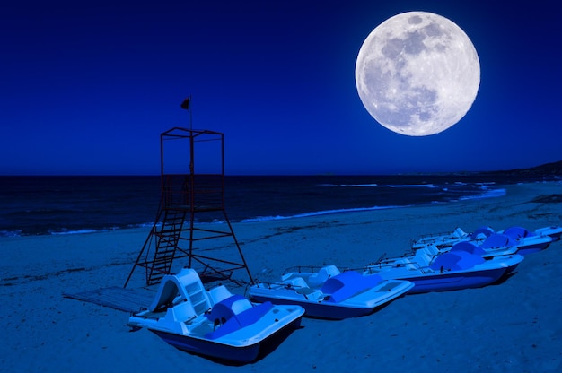 Foto torre di salvataggio rossa sulla spiaggia di notte