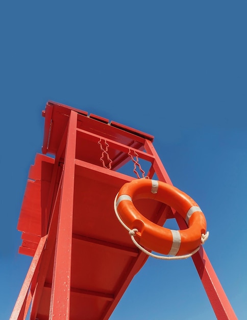 Red rescue tower with a lifeline against the blue sky