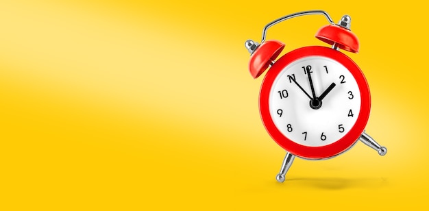 Red retro alarm clock isolated on yellow